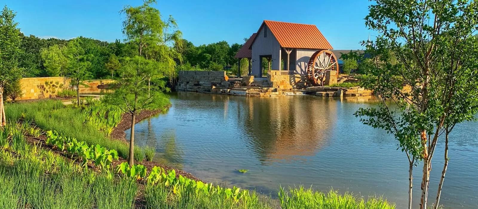 Scenic pond and historic watermill in Argyle, Texas on a clear day.